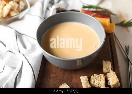 Ciotola con fonduta di formaggio e crostini sul tavolo Foto Stock