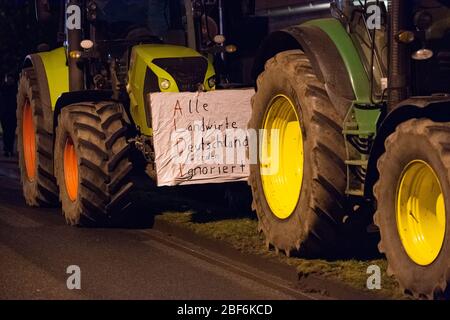 09 marzo 2020, bassa Sassonia, Ohlendorf (seevetal): I trattori sono parcheggiati sulla strada del villaggio con un poster che dice "ALDI - tutti gli agricoltori tedeschi sono ignorati". Centinaia di agricoltori hanno dimostrato con i loro trattori di fronte ai campi di Aldi-Nord. A Seevetal (distretto di Harburg), circa 400 trattori si trovavano di fronte alla strada di accesso alla fattoria durante la notte. Foto: Jonas Walzberg/dpa Foto Stock