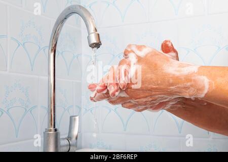 Lavarsi le mani sfregando con sapone donna per la prevenzione del virus dell'influenza invernale, igiene per smettere di diffondere germi. Donna lava le mani con sapone. Lavando le mani Foto Stock