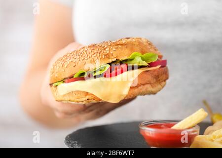 Donna con kebab doner saporito in panino, patatine fritte e salsa, primo piano Foto Stock