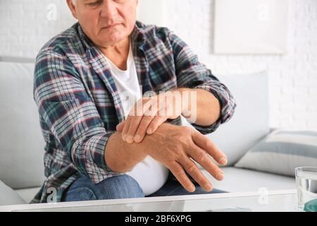 Uomo anziano affetto da sindrome di Parkinson a casa Foto Stock