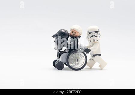 infortunato darth vader su sedia a rotelle con storm trooper che lo spinge. I minicalci LEGO sono prodotti da Lego. Foto Stock