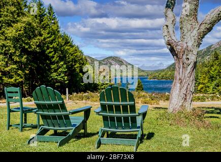 Sedie verdi Adirondack che si affacciano sul lago nel Maine Foto Stock