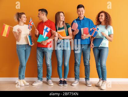 Giovani studenti di scuola di lingua vicino al muro di colore Foto Stock