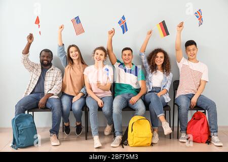 Giovani studenti di scuola di lingua vicino al muro di colore Foto Stock