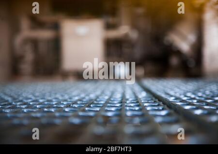 Contesto industriale astratto. Un pavimento a griglia nel magazzino della fabbrica. Breve profondità di campo. Foto ravvicinata. Foto Stock