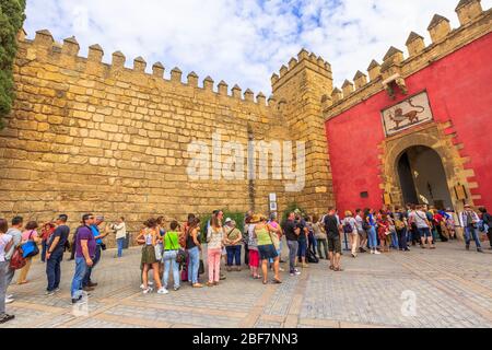 Siviglia, Andalusia, Spagna - 19 aprile 2016: Fila di turisti di fronte alla porta del Leone, ingresso al reale Alcazar di Siviglia. La porta è l'accesso principale Foto Stock