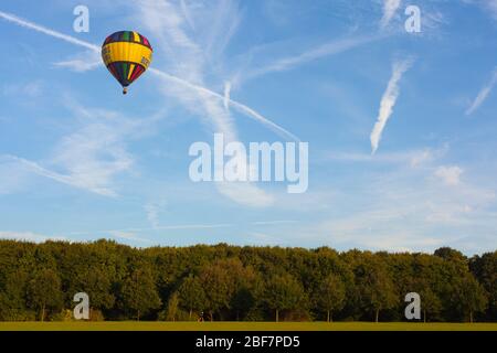 Una mongolfiera in un cielo blu con nuvole incrociate Foto Stock