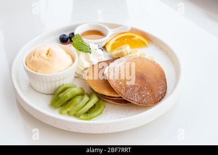 Pancake con frutta, gelato alla vaniglia e panna montata Foto Stock