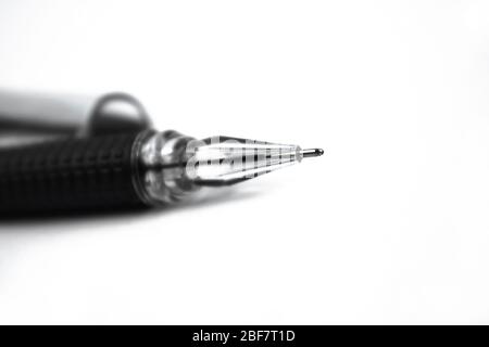 Immagine ravvicinata di una punta di una penna a sfera di colore nero posizionata su uno sfondo isolato bianco Foto Stock