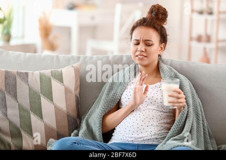 Giovane donna afro-americana incinta con allergia lattiera a casa Foto Stock