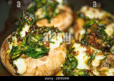 Funghi cotti al forno con formaggio, cipolle verdi e aneto. Primo piano Foto Stock