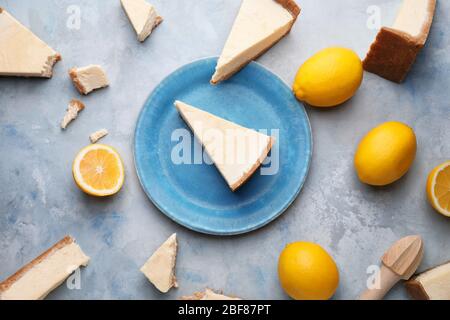 Composizione con pezzi di dolce gustoso cheesecake e limoni su sfondo chiaro Foto Stock