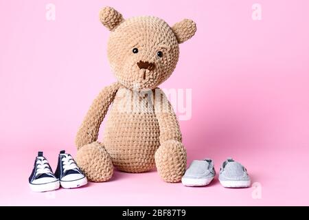Orsacchiotto con scarpe per bambini su sfondo colorato Foto Stock
