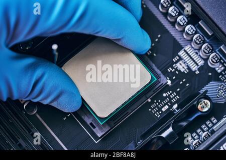 Ingegnere elettronico di tecnologia informatica. Installazione del processore sulla scheda madre. Riparazione PC, tecnico e supporto del settore. Foto Stock