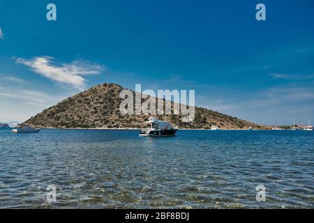 Ristorante e fiori di bougainvillea sulla spiaggia a Gumusluk, Bodrum. Sedie colorate, tavoli e fiori nella città di Bodrum vicino al bellissimo Mar Egeo. Foto Stock