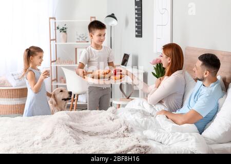 Bambini piccoli che portano la colazione dei genitori a letto Foto Stock