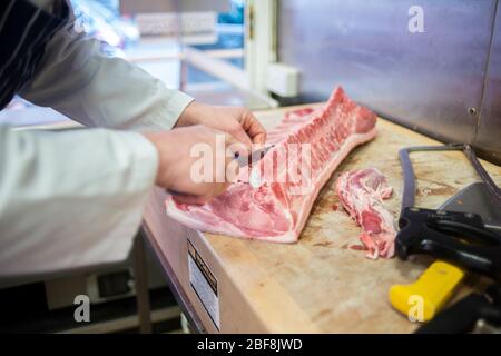 Un macellaio prepara un alto-welfarestuk per vendere nel suo negozio macellaio Foto Stock