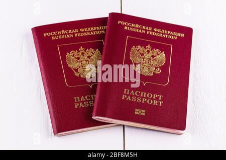 Due passaporti biometrici stranieri della Federazione Russa su sfondo di legno bianco. Il concetto di viaggiare all'estero. Foto Stock