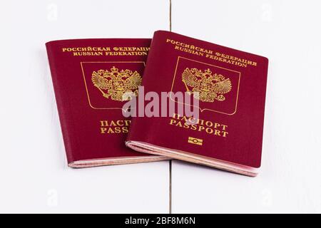 Due passaporti biometrici stranieri della Federazione Russa su sfondo di legno bianco. Il concetto di viaggiare all'estero. Foto Stock