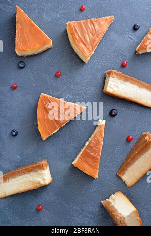 Fette di formaggio caramello dolce con frutti di bosco su sfondo scuro Foto Stock