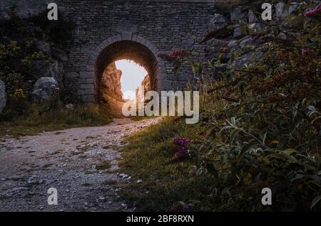 Il vecchio ponte di cava con luce solare dorata che splende attraverso a Tout Quarry, Isola di Portland, Weymouth, Dorset, Regno Unito Foto Stock