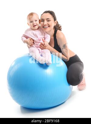 Giovane madre sportiva e il suo bambino facendo esercizi con il flipper su sfondo bianco Foto Stock