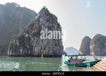 Barca ormeggiata circondata da belle scogliere calcaree di ha Long Bay, Vietnam. Foto Stock