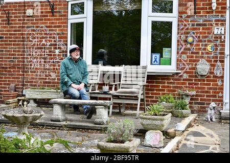 Coronavirus. Rimani a casa. Proteggere l'NHS, salvare vite umane. Un nonno siede davanti ai messaggi della sua nipote che non riesce a vedere a causa della pandemia del coronavirus. Sidcup, Kent. REGNO UNITO Foto Stock