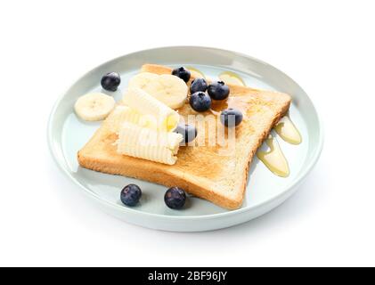 Gustoso pane tostato con miele, burro e frutta su fondo bianco Foto Stock