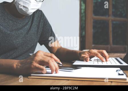 Uomo d'affari che lavora con computer portatile su tavolo di legno a casa. Concetto di business online funzionante. Foto Stock