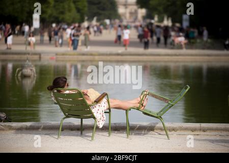 Donna che dorme accanto al Bassin ottogonale nel Giardino delle Tuileries, Parigi Foto Stock