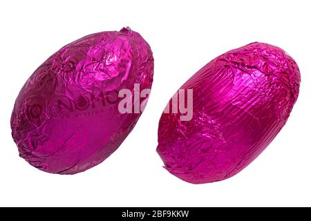 Uova di Pasqua avvolte con fogli viola e rosa - Nomo non manca Vegan e Free from Fruit & Crunch Egg on left Foto Stock