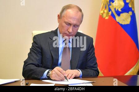 Novo-Ogaryovo, Mosca, Russia. 17 Aprile 2020. Il presidente russo Vladimir Putin prende appunti durante una videoconferenza con i membri del governo per discutere della crescente capacità ospedaliera di combattere il coronavirus dalla residenza di stato di Novo-Ogaryovo il 17 aprile 2020 fuori Mosca, Russia. Putin sta tenendo incontri per teleconferenza dalla sua residenza a causa della COVID-19, pandemia di coronavirus. Credit: Alexei Druzhinin/Kremlin Pool/Alamy Live News Foto Stock