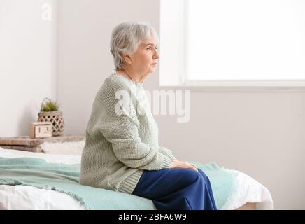 Donna anziana che soffre di disabilità mentale a casa Foto Stock
