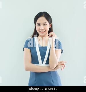 Ritratto di donna d'affari asiatica sorridente in piedi con le braccia piegate e guardando la macchina fotografica isolato su sfondo grigio Foto Stock