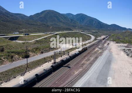 Treno merci che sale al Cajon Pass nella contea di San Bernardino, parte della grande catena logistica della California meridionale Foto Stock