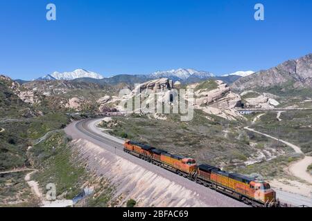 Treno merci che sale al Cajon Pass nella contea di San Bernardino, parte della grande catena logistica della California meridionale Foto Stock