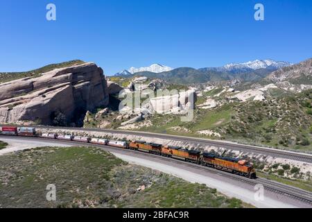 Treno merci che sale al Cajon Pass nella contea di San Bernardino, parte della grande catena logistica della California meridionale Foto Stock