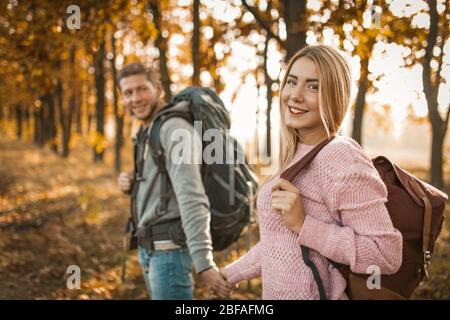 Happy Travellers a piedi un percorso autunnale della foresta all'aperto Foto Stock