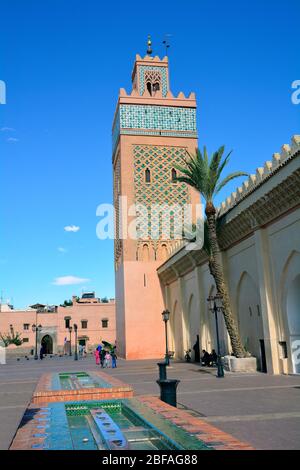 Marrakech, Marocco - 22 novembre 2014: Persone non identificate e moschea con minareto in stile tradizionale Foto Stock