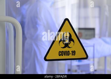 Cartello di avvertenza per i rischi biologici sulla porta del reparto di isolamento contagioso. Concetto di epidemia di Coronavirus Foto Stock