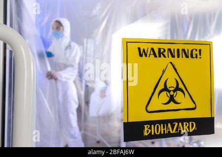 Cartello di avvertenza per i rischi biologici sulla porta del reparto di isolamento contagioso. Concetto di epidemia di Coronavirus Foto Stock