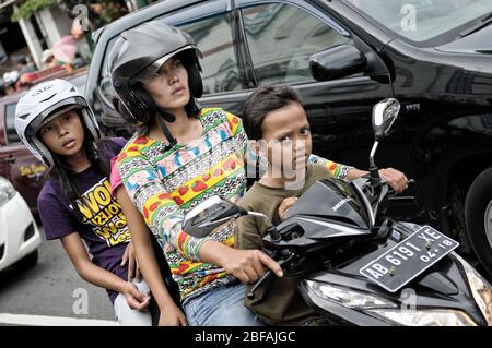 Donna e bambini su uno scooter a Yogyakarta, Java, Indonesia Foto Stock