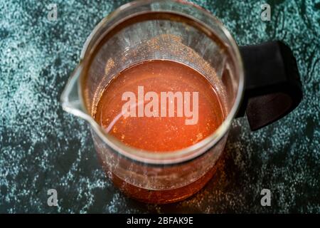 Acqua o tè Sumac e spezie Sumac rosso macinato essiccato con chiodi di garofano in French press. Pronto a bere. Foto Stock