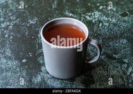 Acqua o tè Sumac e spezie Sumac rosso macinato essiccato con chiodi di garofano in vetro. Pronto a bere. Foto Stock