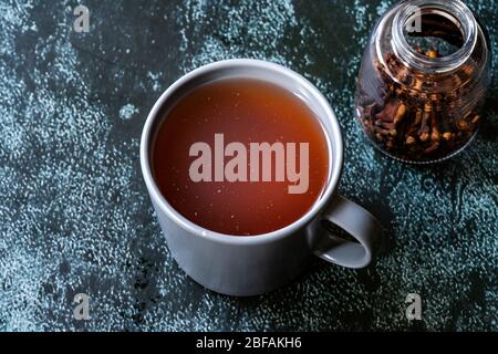 Acqua o tè Sumac e spezie Sumac rosso macinato essiccato con chiodi di garofano in vetro. Pronto a bere. Foto Stock