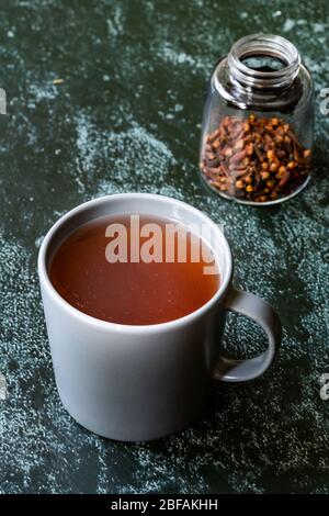 Acqua o tè Sumac e spezie Sumac rosso macinato essiccato con chiodi di garofano in vetro. Pronto a bere. Foto Stock