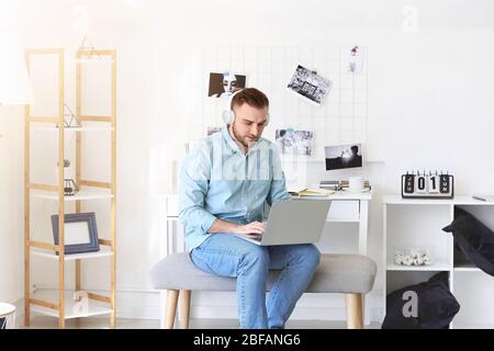 Giovane uomo con notebook che lavora a casa Foto Stock