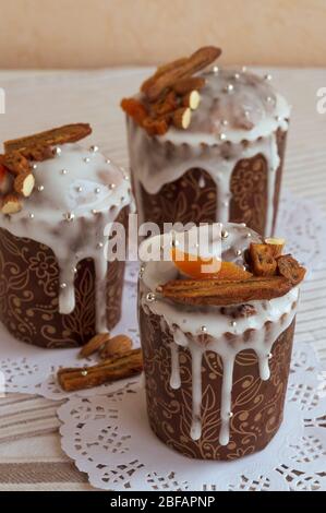 Foto verticale di elegante tradizionale torta di Pasqua ortodossa e due altri sullo sfondo sui tovaglioli bianchi decorati da banane secche, Foto Stock